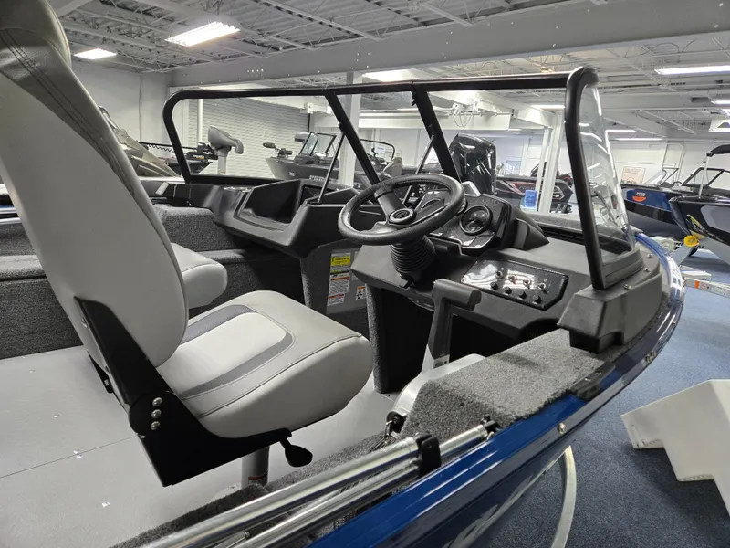 Slide: The Image of 2025 Princecraft Holiday 162 WS MAX boat interior with steering wheel and seating. - 2