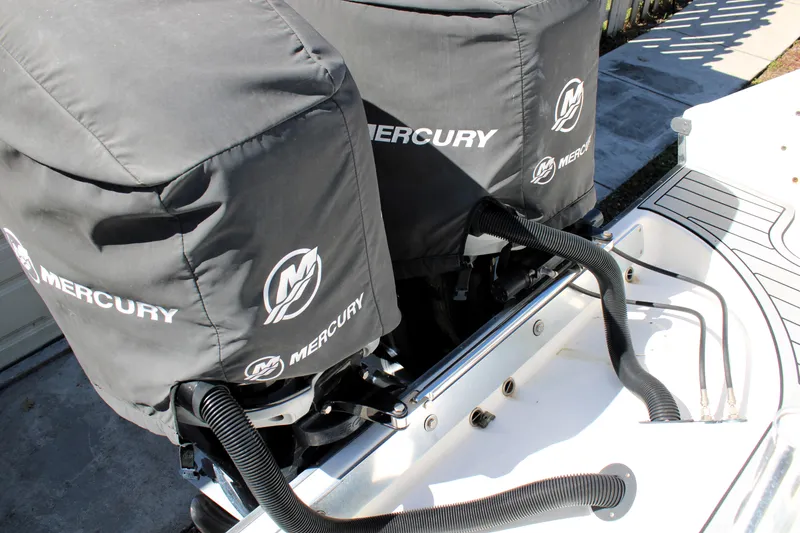 Slide: The Image of Twin Mercury outboard motors on a 2008 Edgewater 318CC boat, covered and secured. - 13