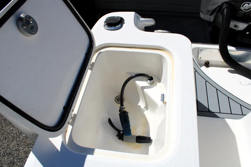 Slide: The Image of Open storage compartment on a 2008 Edgewater 318CC boat with hose inside. - 17