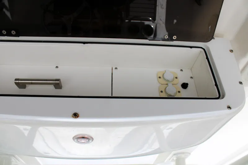 Slide: The Image of 2008 Edgewater 318CC boat console with storage compartment and control knobs. - 28