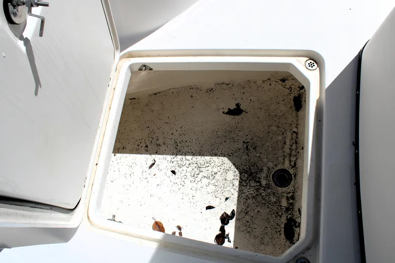 Slide: The Image of Open storage compartment on 2008 Edgewater 318CC boat, showing dirt and debris inside. - 32