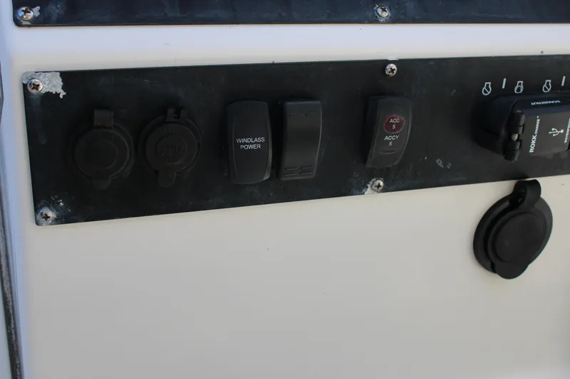 Slide: The Image of Control panel of a 2008 Edgewater 318CC boat with various switches and sockets. - 37