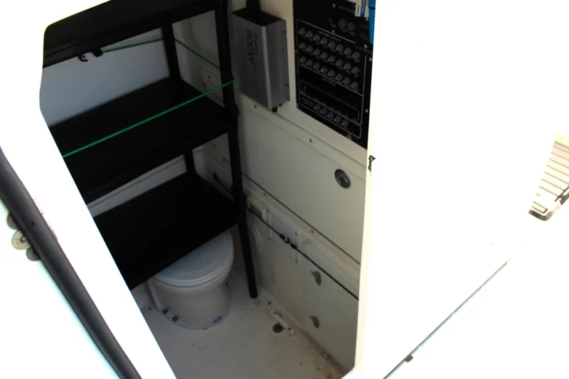 Slide: The Image of Interior of 2008 Edgewater 318CC boat showing storage shelves and a compact toilet. - 41