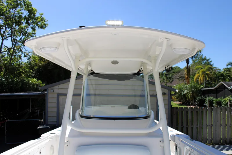 Slide: The Image of 2008 Edgewater 318CC boat with T-top, parked outdoors on a sunny day. - 47