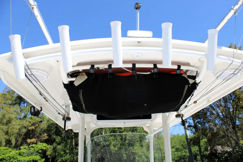 Slide: The Image of 2008 Edgewater 318CC boat with rod holders and canopy against a clear blue sky. - 48