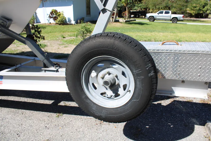 Slide: The Image of Trailer wheel of a 2008 Edgewater 318CC boat on a sunny day. - 5