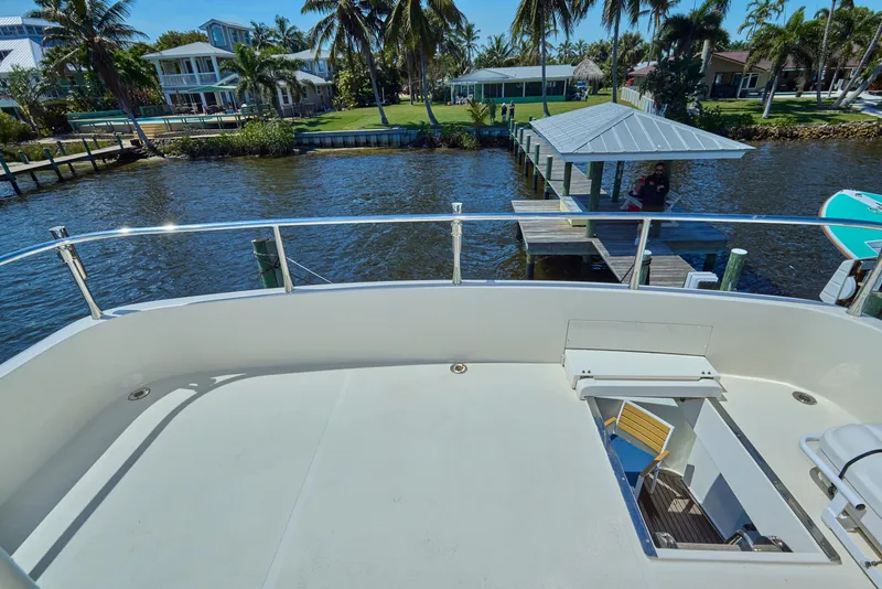 Slide: The Image of 2003 McKinna 58 Pilothouse yacht deck overlooking serene waterfront and dock. - 15