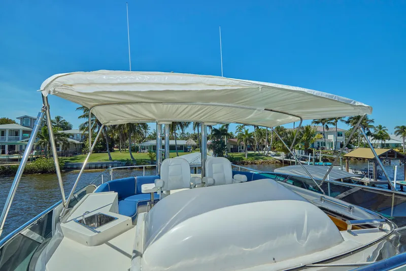 Slide: The Image of 2003 McKinna 58 Pilothouse yacht with canopy, docked near waterfront homes. - 17