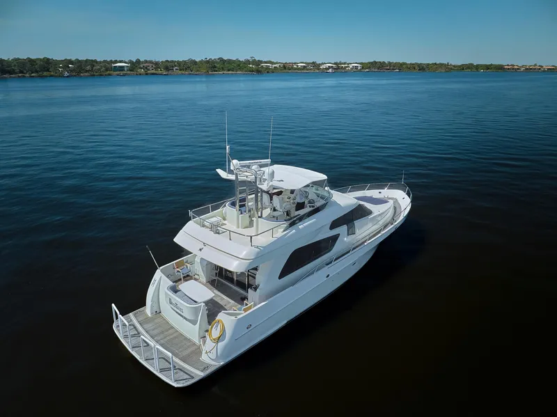 Slide: The Image of 2003 McKinna 58 Pilothouse yacht on calm water, showcasing sleek design and spacious deck. - 48