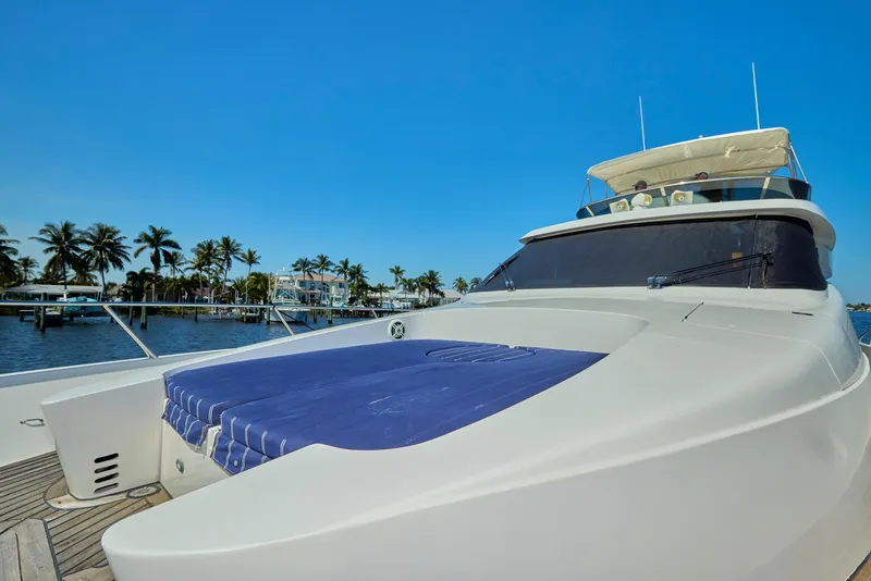 Slide: The Image of 2003 McKinna 58 Pilothouse yacht with blue sunbed, docked near palm trees. - 8
