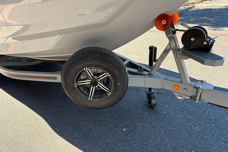 Slide: The Image of Trailer of 2025 MasterCraft NXT23 boat with black wheel on asphalt. - 11