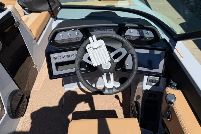 Slide: The Image of 2025 MasterCraft NXT23 boat dashboard with steering wheel and control panel. - 14
