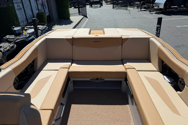 Slide: The Image of 2025 MasterCraft NXT23 boat interior with beige seating and spacious layout. - 19