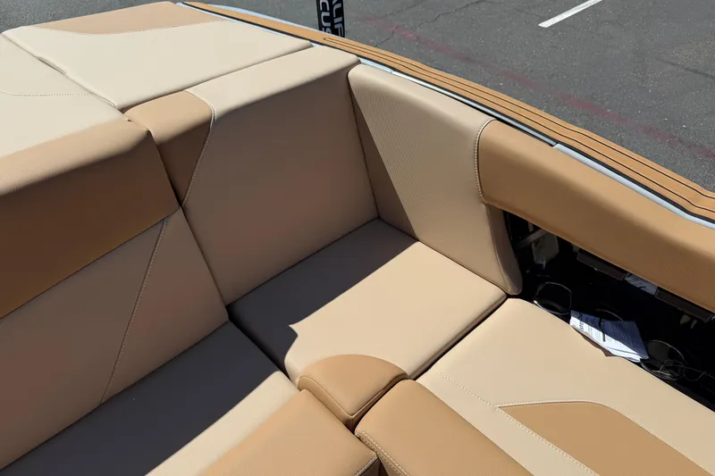 Slide: The Image of 2025 MasterCraft NXT23 boat interior with beige and tan seating, showcasing luxury design. - 20