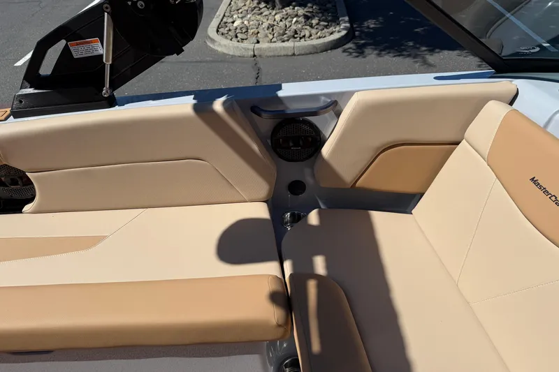 Slide: The Image of 2025 MasterCraft NXT23 boat interior with beige seating and speaker detail. - 22