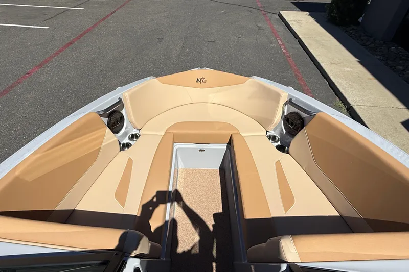 Slide: The Image of 2025 MasterCraft NXT23 boat interior with tan seating and modern design. - 24