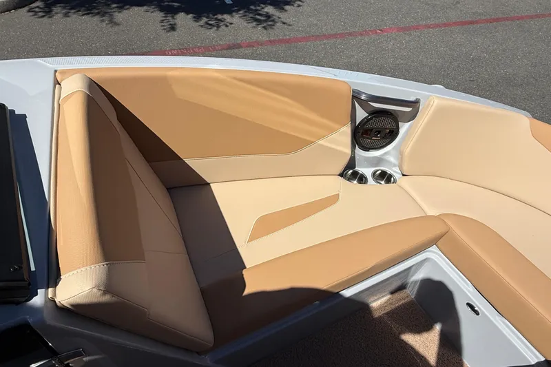 Slide: The Image of 2025 MasterCraft NXT23 boat interior with tan seating and cup holders. - 25