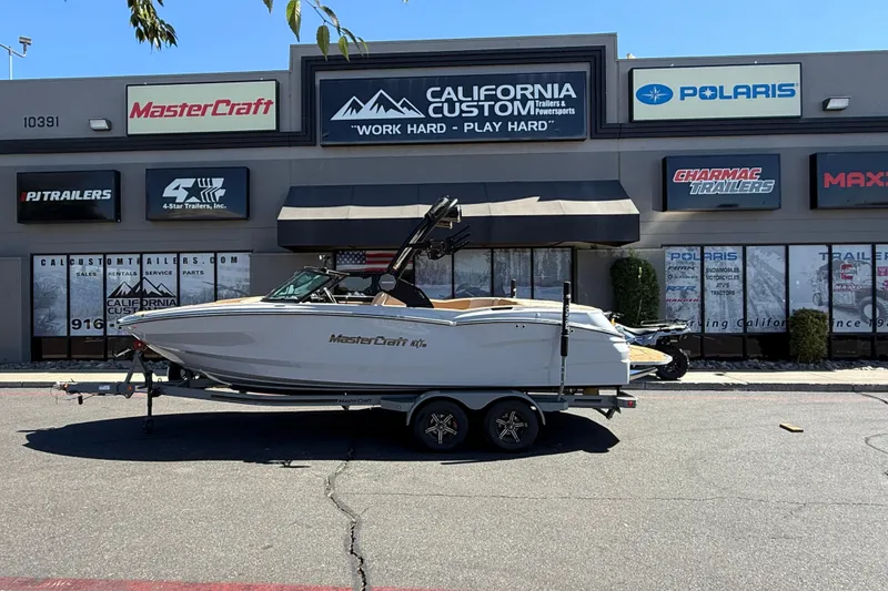 Slide: The Image of 2025 MasterCraft NXT23 boat on trailer outside California Custom Trailers store. - 4