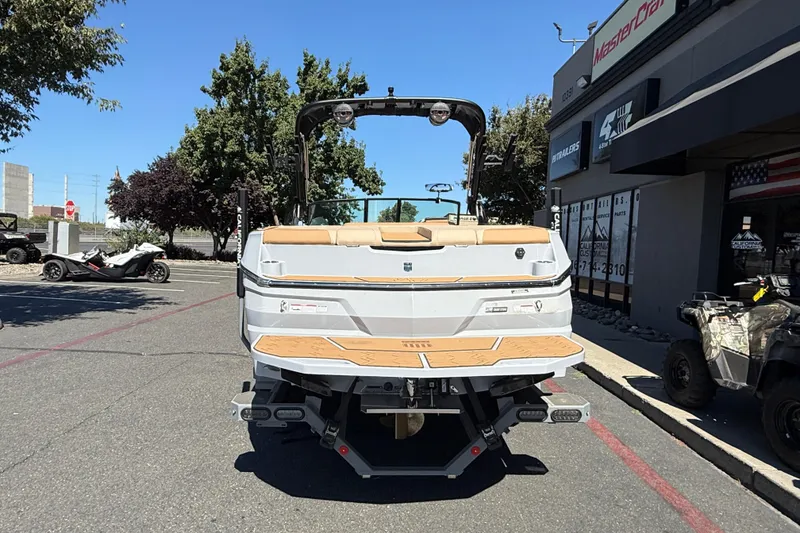 Slide: The Image of 2025 MasterCraft NXT23 boat rear view at dealership, showcasing sleek design and features. - 6