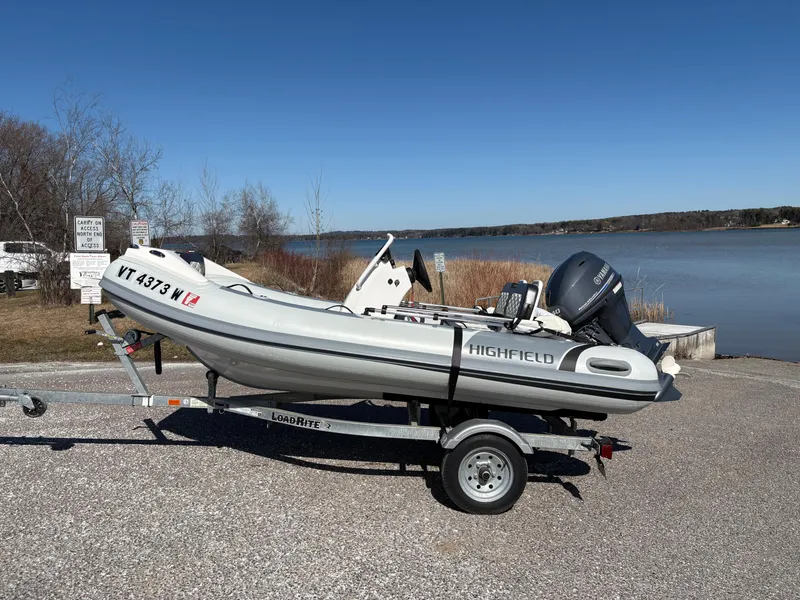Slide: The Image of 2023 Highfield Sport 360 boat on trailer by a lake. - 1