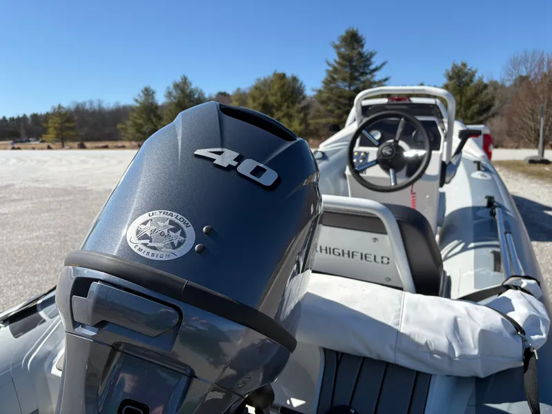 Slide: The Image of 2023 Highfield Sport 360 boat with 40 HP engine, parked outdoors on a sunny day. - 15