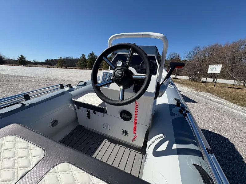 Slide: The Image of 2023 Highfield Sport 360 boat interior with steering wheel, outdoor setting, clear sky. - 16