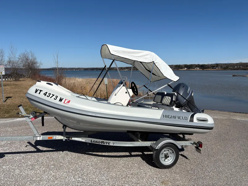 Slide: The Image of 2023 Highfield Sport 360 boat on trailer by a lake, sunny day. - 3