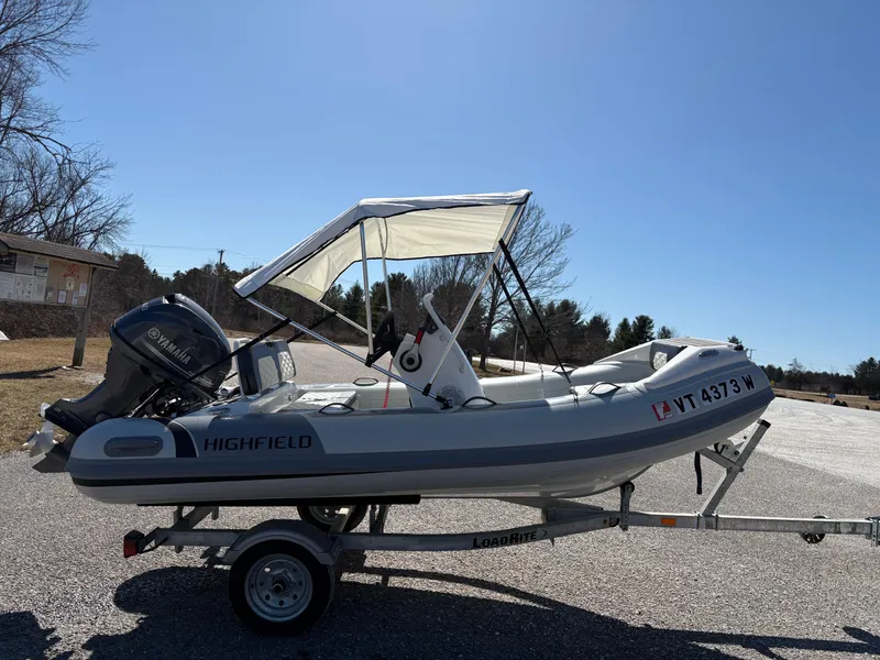 Slide: The Image of 2023 Highfield Sport 360 boat on trailer with canopy, parked outdoors. - 4