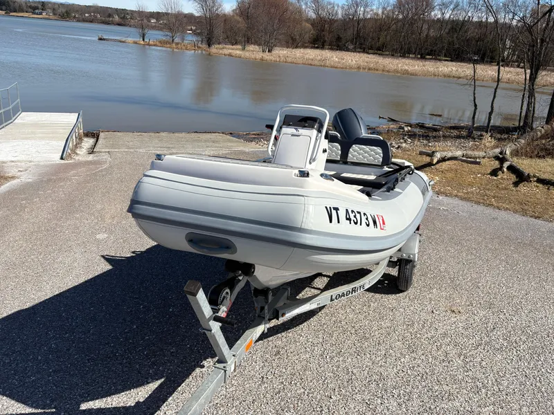 Slide: The Image of 2023 Highfield Sport 360 boat on trailer by a lake. - 6