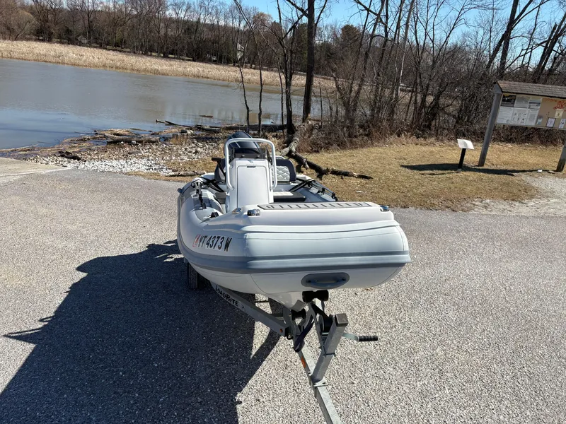 Slide: The Image of 2023 Highfield Sport 360 boat on trailer near a lake, surrounded by trees. - 7