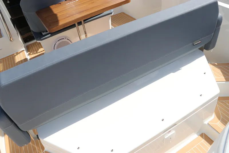 Slide: The Image of Nimbus Tender 8 (2025) boat interior with cushioned seating and wooden table. - 17