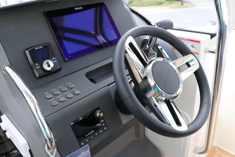 Slide: The Image of Steering wheel and dashboard of 2025 Nimbus Tender 8 boat, featuring modern controls and display. - 24