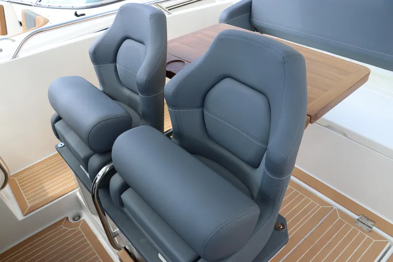 Slide: The Image of Luxury seating on 2025 Nimbus Tender 8 boat with wooden flooring and table. - 25