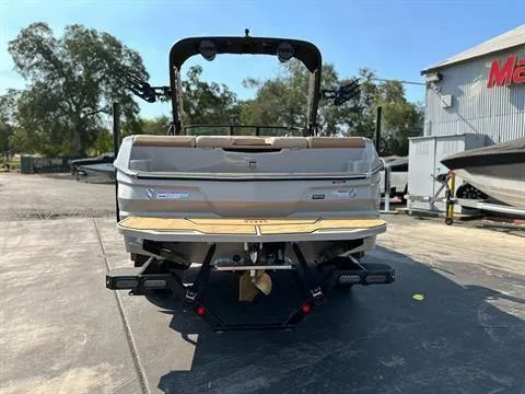 Slide: The Image of 2025 MasterCraft NXT23 boat rear view, parked outdoors on a sunny day. - 3