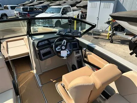 Slide: The Image of 2025 MasterCraft NXT23 boat interior with tan seats and modern dashboard. - 5