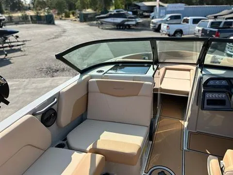 Slide: The Image of 2025 MasterCraft NXT23 boat interior with beige seating and modern dashboard. - 7