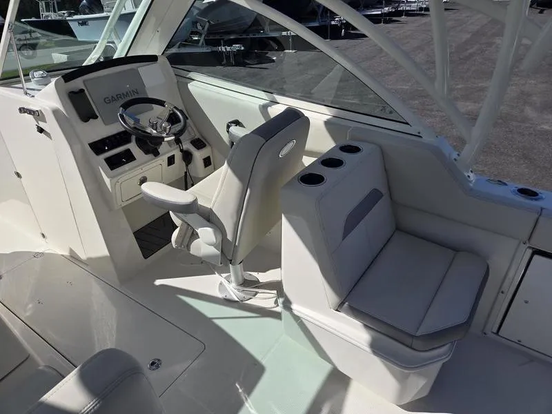 Slide: The Image of 2025 Sailfish 245 DC boat interior with steering console and seating area. - 10