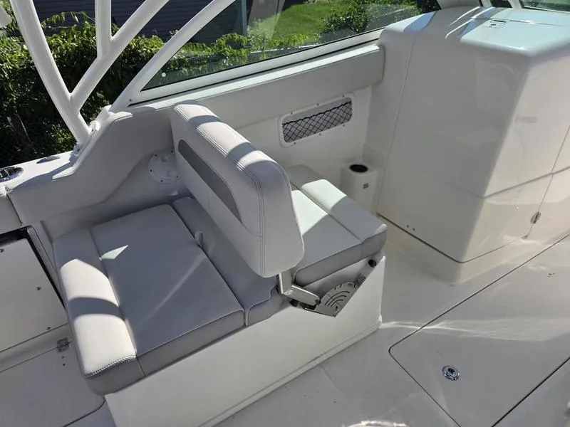 Slide: The Image of 2025 Sailfish 245 DC boat interior with white seating and storage compartment. - 14