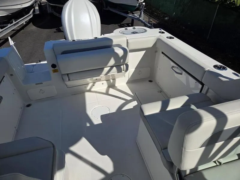 Slide: The Image of 2025 Sailfish 245 DC boat interior with white seating and storage compartments. - 18