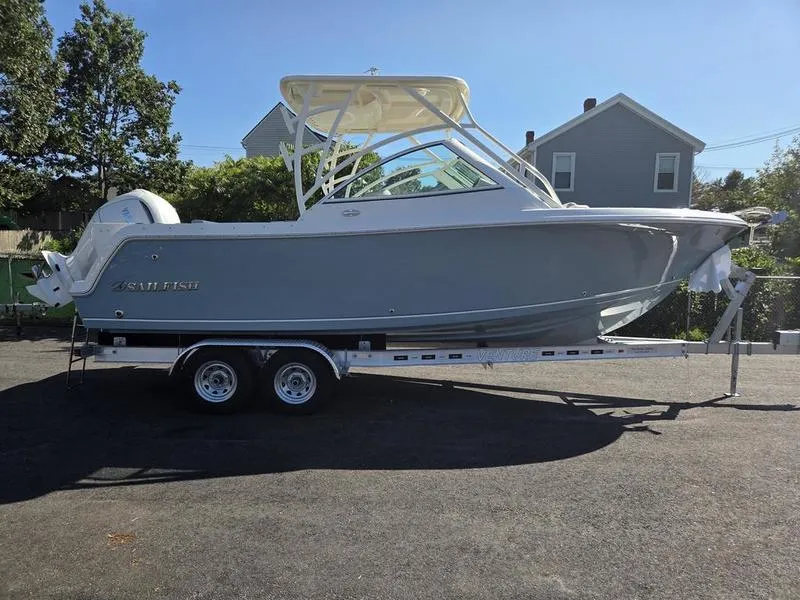Slide: The Image of 2025 Sailfish 245 DC boat on trailer, parked outdoors under clear sky. - 4