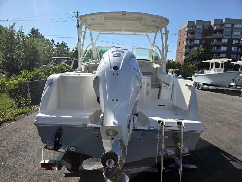 Slide: The Image of 2025 Sailfish 245 DC boat with powerful outboard motor, parked outdoors. - 9