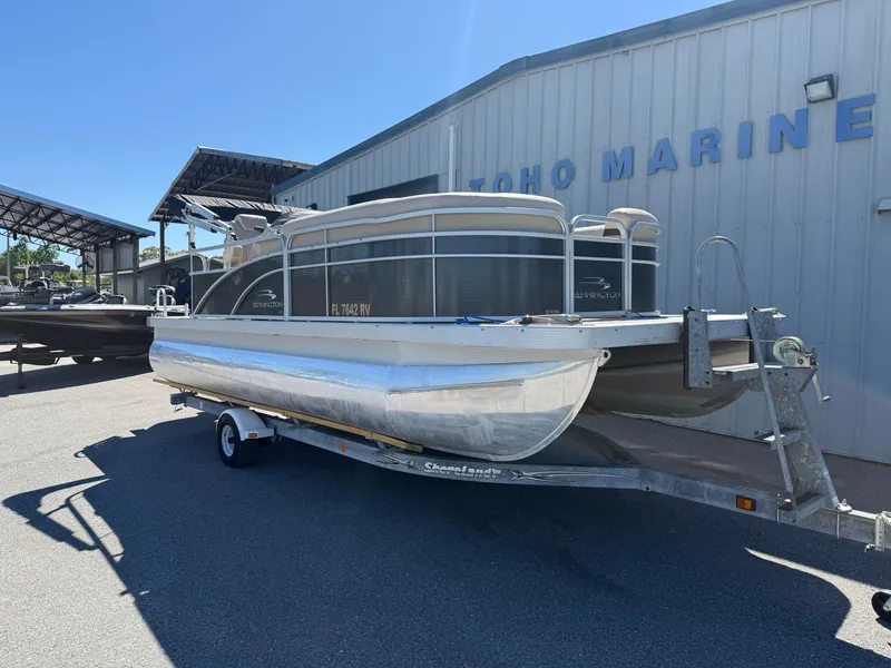 Slide: The Image of 2015 Bennington SLMX pontoon boat on trailer outside marine dealership. - 2