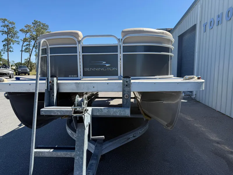 Slide: The Image of 2015 Bennington SLMX pontoon boat on trailer near a building. - 3