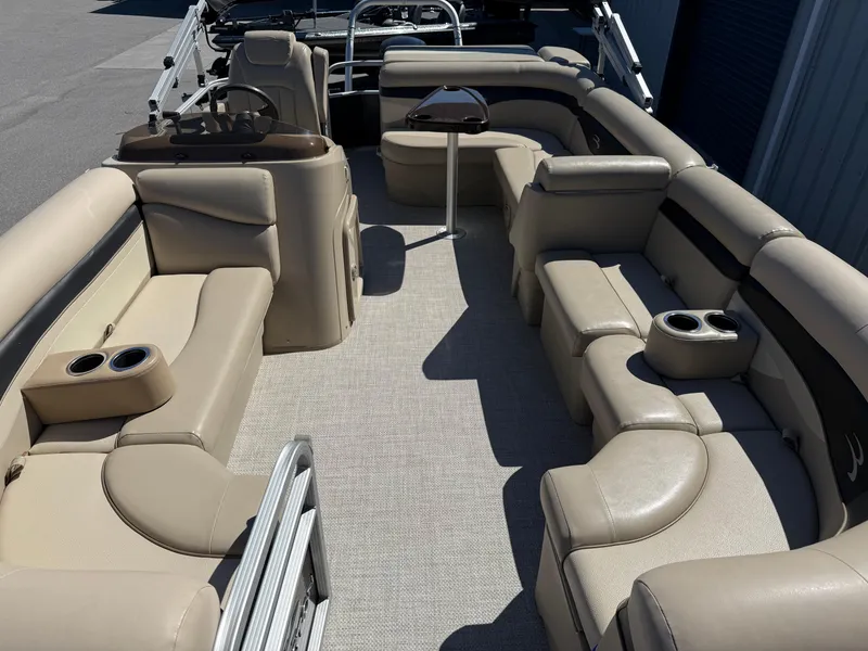 Slide: The Image of 2015 Bennington SLMX pontoon boat interior with beige seating and cup holders. - 5
