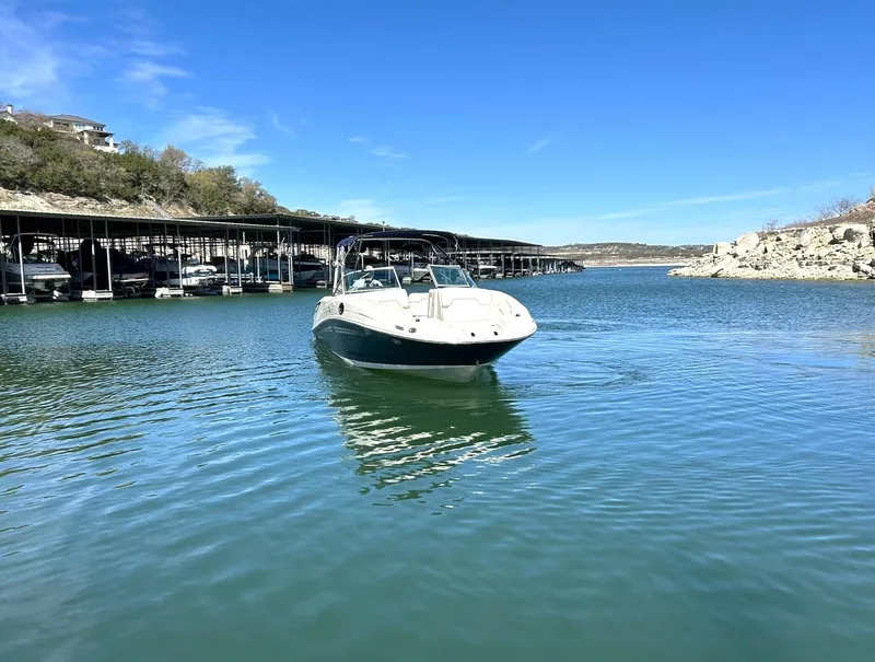 Slide: The Image of 2008 Sea Ray 290 Sundeck boat cruising on a calm lake under a clear blue sky. - 11