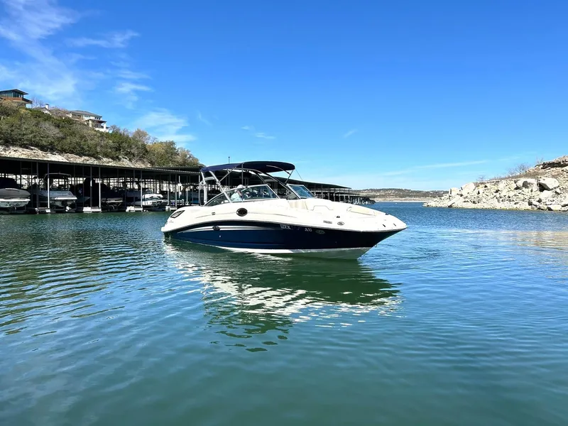 Slide: The Image of 2008 Sea Ray 290 Sundeck boat on calm water under clear blue sky. - 12