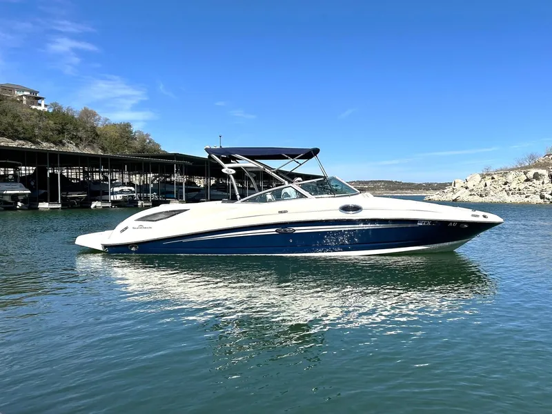 Slide: The Image of 2008 Sea Ray 290 Sundeck boat on calm water under clear blue sky. - 14