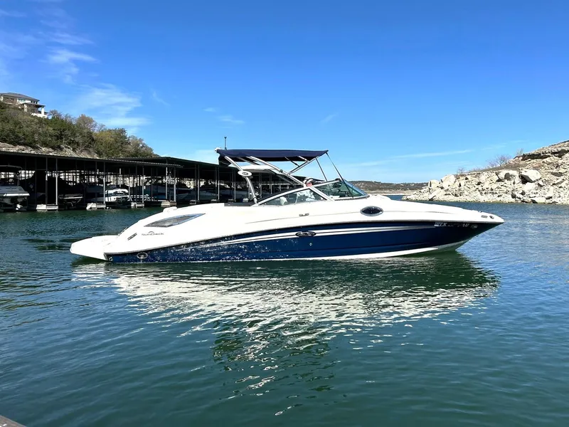 Slide: The Image of 2008 Sea Ray 290 Sundeck boat on calm water under clear blue sky. - 15