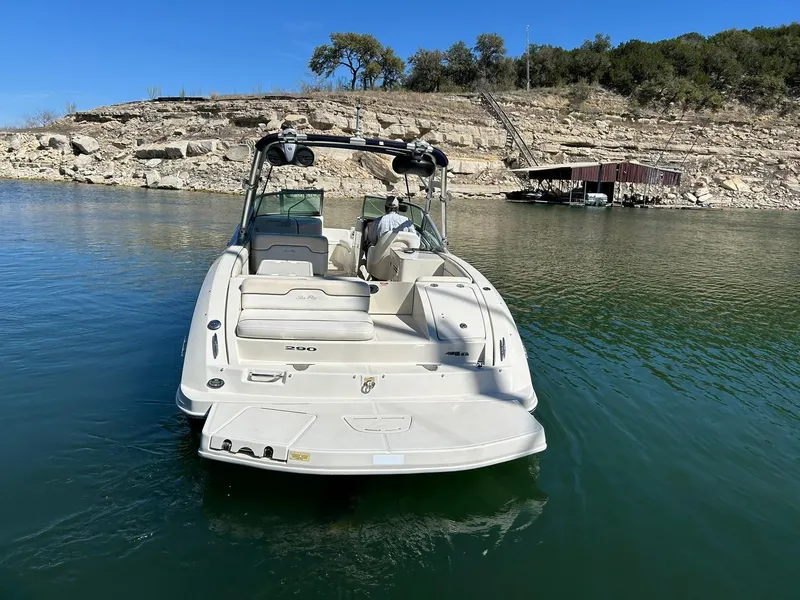 Slide: The Image of 2008 Sea Ray 290 Sundeck boat on calm water near rocky shoreline. - 18