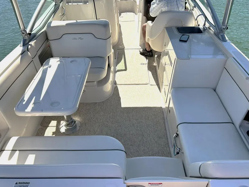 Slide: The Image of 2008 Sea Ray 290 Sundeck interior with white seating and table on a sunny day. - 23